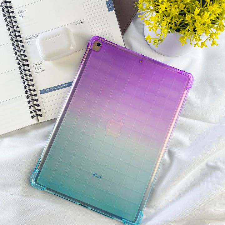 A transparent-colored silicone case with corner-bumpers covering the back of an Apple iPad. The top-half purple blends to the teal-colored bottom-half. #color_purple-green