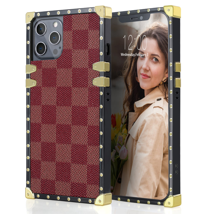 A box-shaped, TPU, iPhone 12 Pro Max case, with gold corner bumpers and gold rivets on its black borders. The case’s back is designed with red and pink checkered boxes.  #color_red-checkered