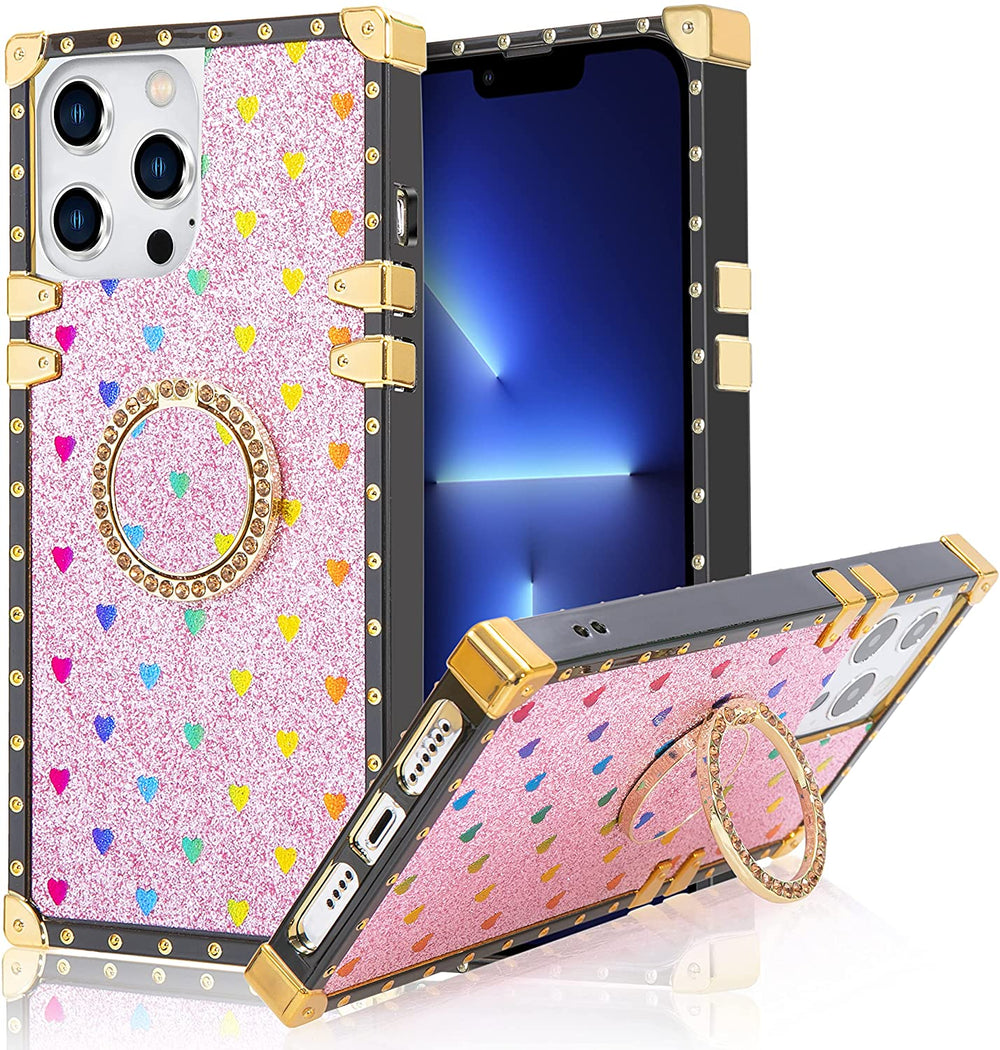 An Apple iPhone 13 Pro TPU case; ring-handle-kickstand; rectangular-shaped; black trim with gold-rivets; gold corner bumpers; with glittery-rainbow hearts in a pink backdrop. #color_pink-glittery-hearts