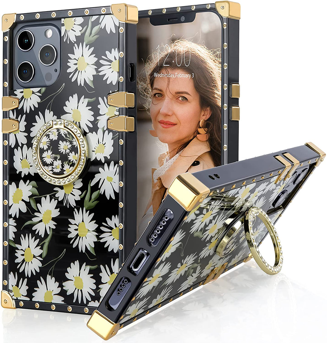 An Apple iPhone 13 Pro case; ring-handle-kickstand; rectangular-shaped; black trim with gold-rivets; gold corner bumpers; with white daises behind a black backdrop. #color_daisies