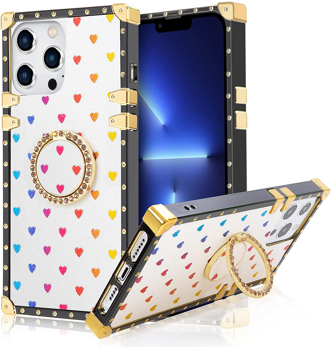 An Apple iPhone 13 Pro TPU case; ring-handle-kickstand; rectangular-shaped; black trim with gold-rivets; gold corner bumpers; with glittery-rainbow hearts in a white backdrop. #color_white-glittery-hearts