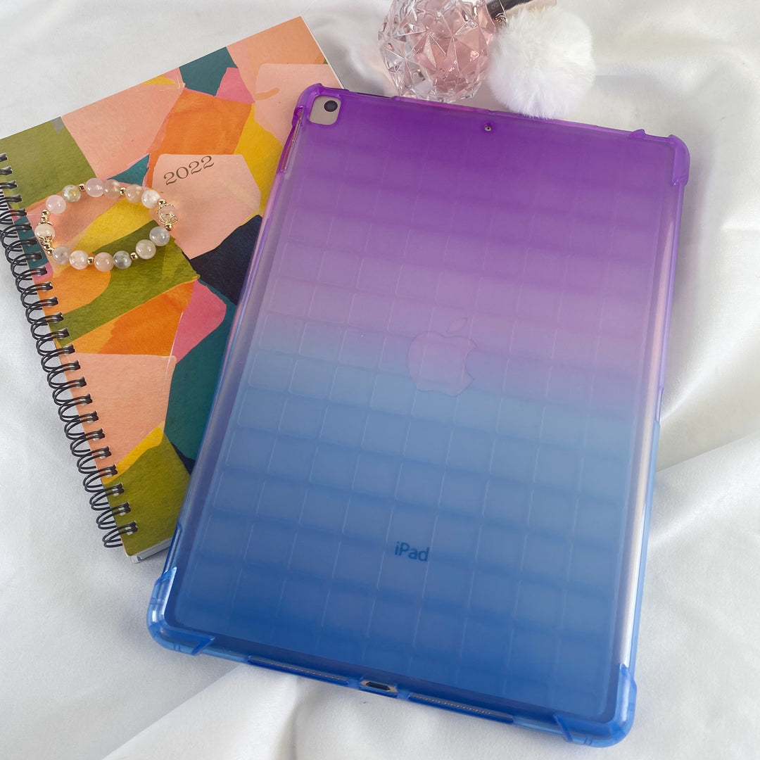 A transparent-colored silicone case with corner-bumpers covering the back of an Apple iPad. The top-half purple blends to the blue-colored bottom-half. #color_purple-blue