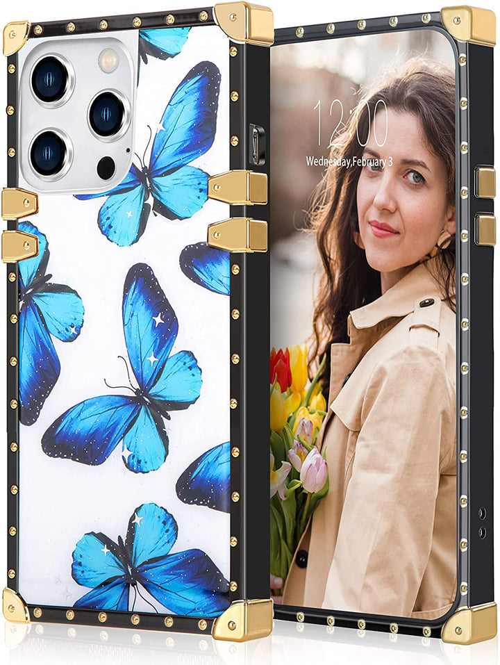 A box-shaped, TPU, iPhone 12 Pro Max case, with gold corner bumpers and gold rivets on its black borders. The case’s back is designed with glitter and blue butterflies. It also has a gold trim ring that doubles as a handle and kickstand.     #color_blue-butterfly-silver-glitter