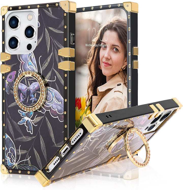 An Apple iPhone 13 Pro Max case; ring-handle-kickstand; rectangular-shaped; black trim with gold-rivets; gold corner bumpers; with holographic butterflies and leaves along a black backdrop. #color_purple-butterfly-holographic-silver-trim