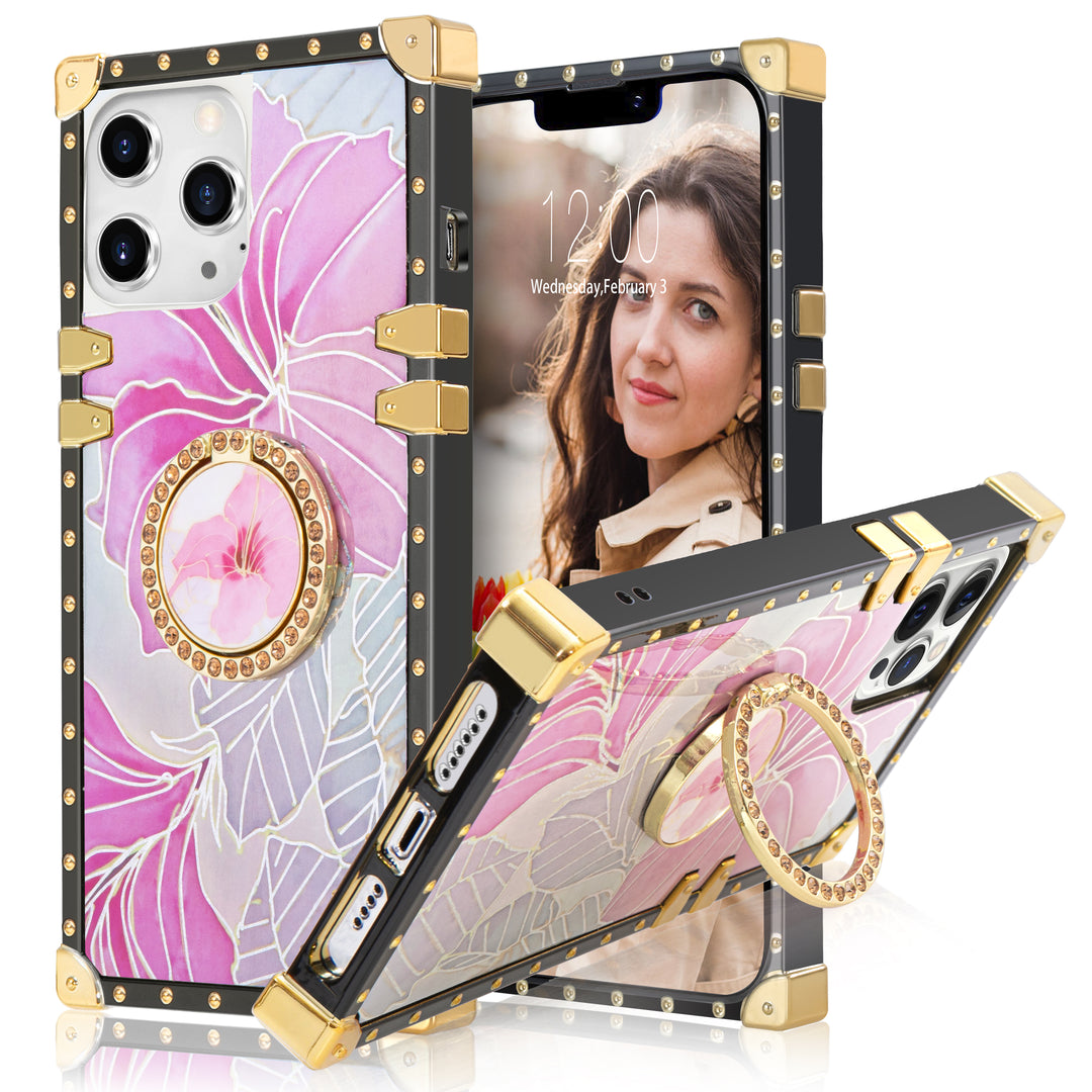 A box-shaped, TPU, iPhone 12 Pro Max case, with gold corner bumpers and gold rivets on its black borders. The case’s back is designed with pink flowers and silver outlines. A gold trim ring doubles as a handle and kickstand for the case. #color_pink-flower-silver-holo