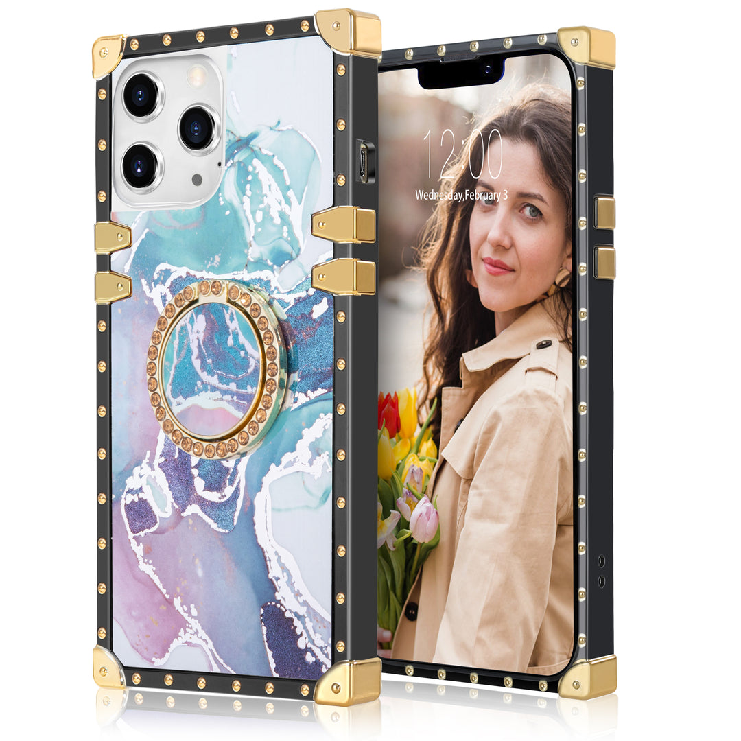 A box-shaped, TPU, iPhone 12 Pro Max case, with gold corner bumpers and gold rivets on its black borders. The case’s back is designed with blue, purple, and white marbling. A gold trim ring doubles as a handle and kickstand for the case. #color_marble-holo-blue-purple-white