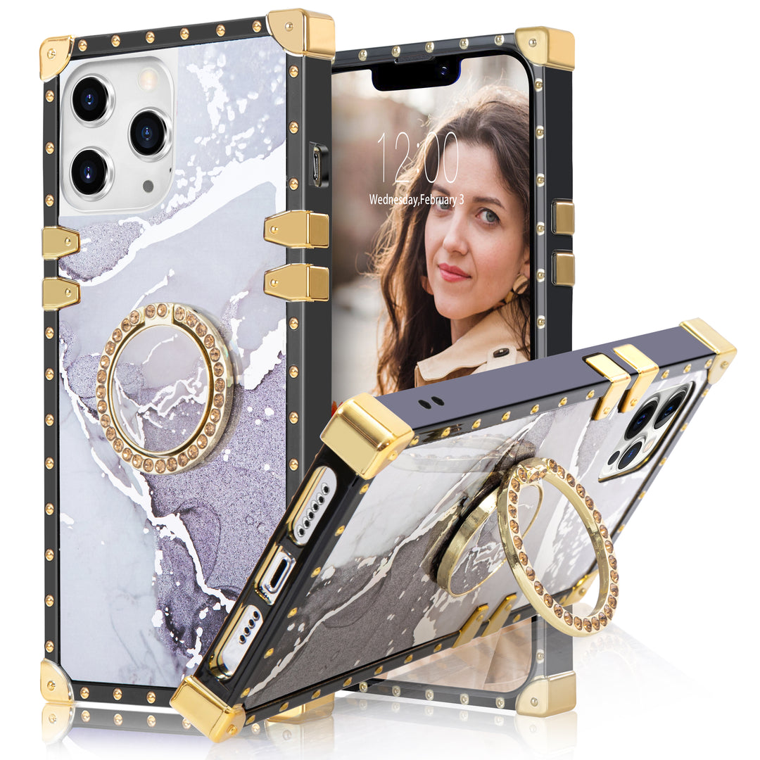 A box-shaped, TPU, iPhone 12 Pro Max case, with gold corner bumpers and gold rivets on its black borders. The case’s back is designed with gray and white marbling. A gold trim ring doubles as a handle and kickstand for the case. #color_marble-holo-white