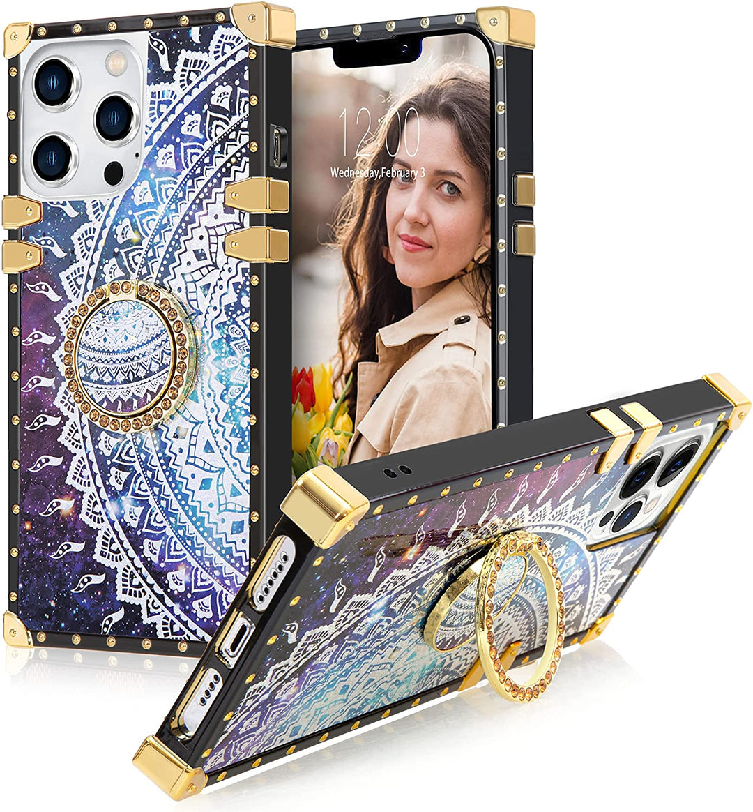 A box-shaped TPU case with gold corner bumpers and gold rivets on its black borders. The case’s back design has a white-quarter-mandala sun in a blue-purple cosmic backdrop. The case has a gold ring handle that doubles as a holder and kickstand. #color_holo-purple-cosmo-silver-quarter-sun