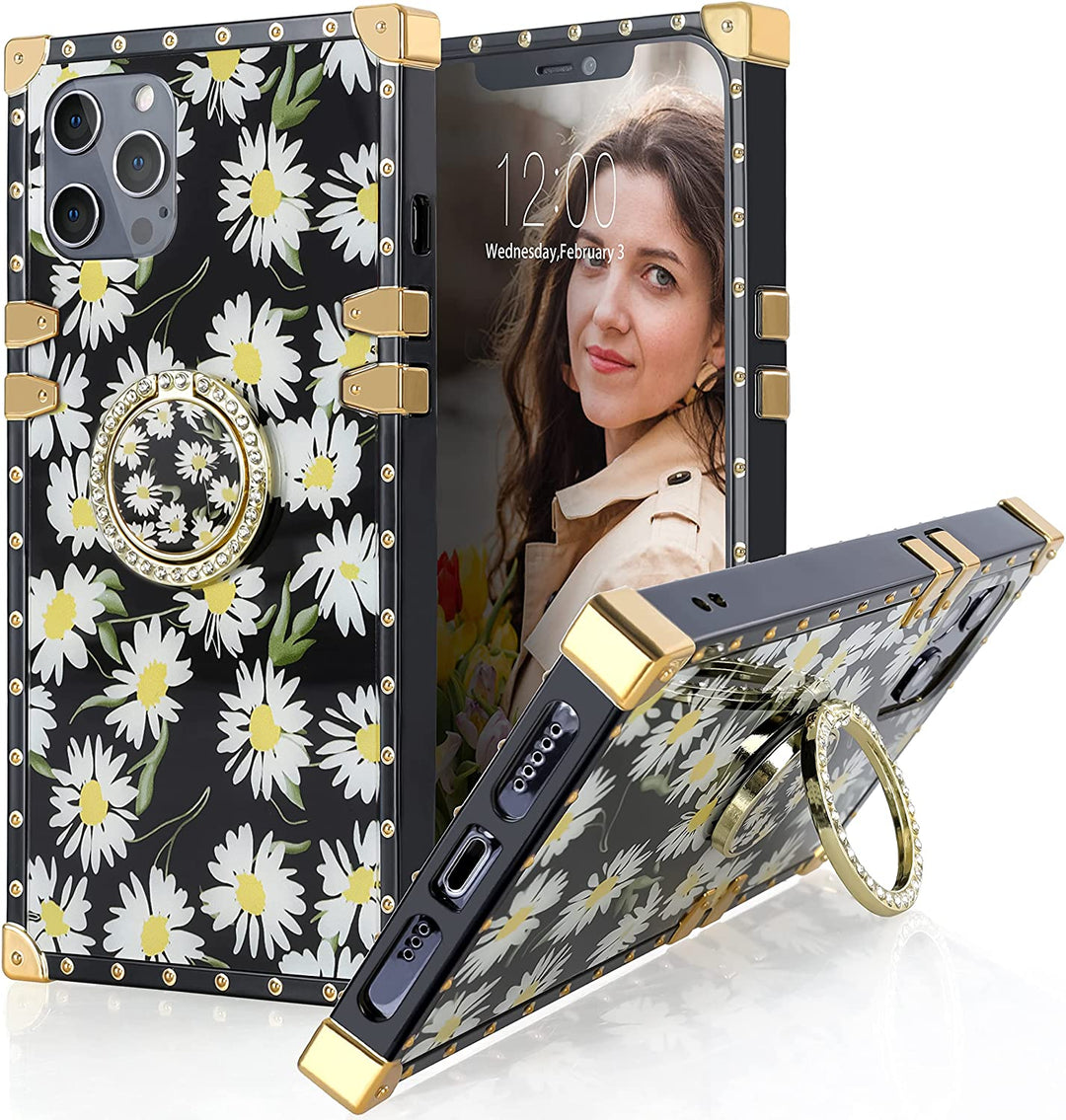 An Apple iPhone 12 or iPhone 12 Pro case; ring-handle-kickstand; rectangular-shaped; black trim with gold-rivets; gold corner bumpers; with white daises behind a black backdrop. #color_daisies